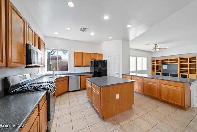 kitchen featuring a healthy amount of sunlight, stainless steel appliances, a center island, and light tile patterned floors