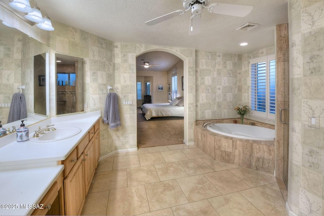 full bath with tile patterned flooring, tile walls, and a textured ceiling