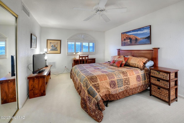 carpeted bedroom with visible vents and a ceiling fan