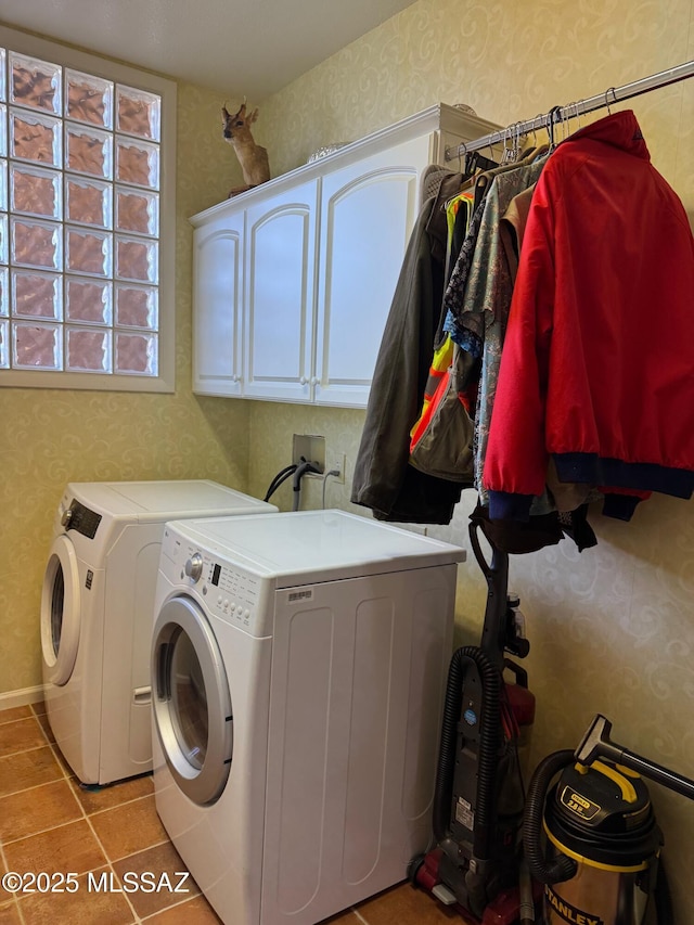 washroom featuring wallpapered walls, light tile patterned floors, washer and clothes dryer, and cabinet space