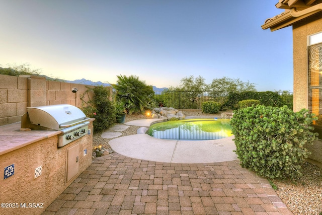 view of swimming pool with a fenced backyard, area for grilling, a grill, a fenced in pool, and a patio area