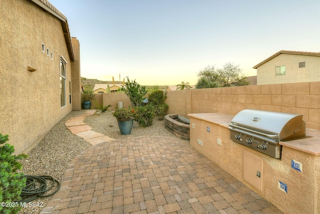 view of patio with area for grilling, grilling area, and a fenced backyard