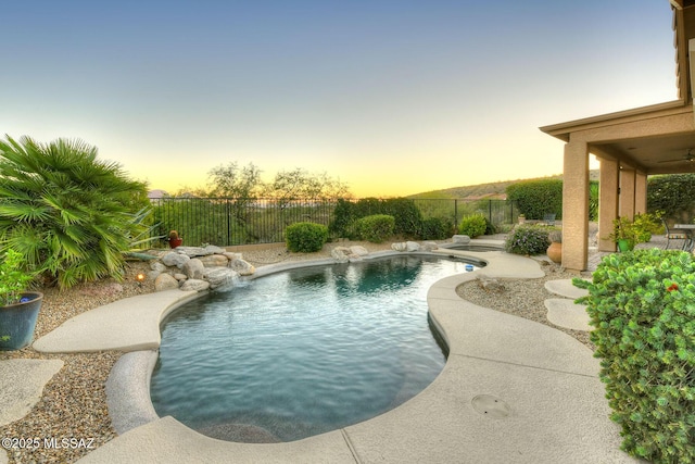 pool at dusk with a fenced in pool, a patio area, and a fenced backyard