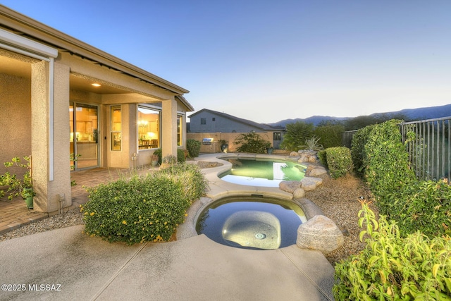 view of pool featuring a fenced in pool, a fenced backyard, a patio, and an in ground hot tub