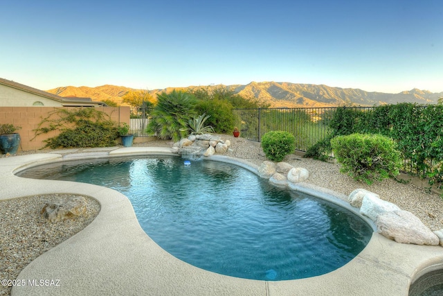 view of swimming pool featuring a fenced backyard, a mountain view, and a fenced in pool