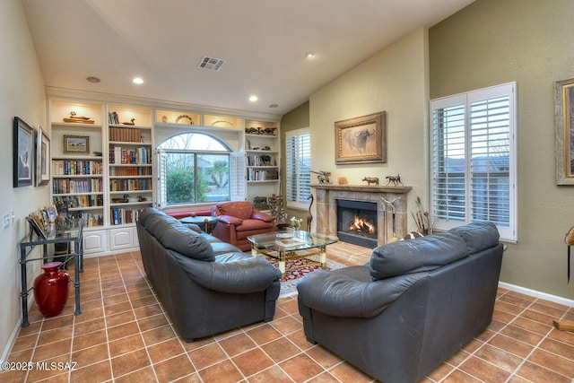 living area with lofted ceiling, tile patterned flooring, a fireplace, visible vents, and built in features