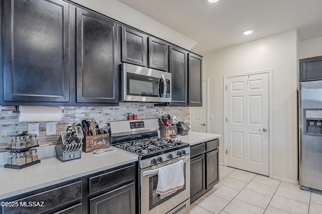 kitchen featuring tasteful backsplash, stainless steel appliances, and light tile patterned floors