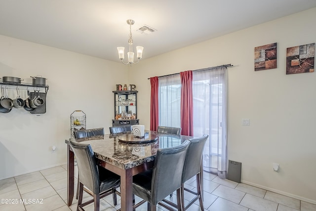 tiled dining area featuring an inviting chandelier