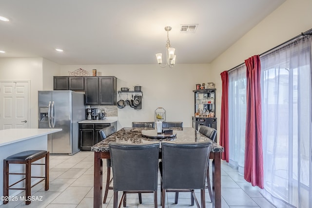 tiled dining area with a chandelier