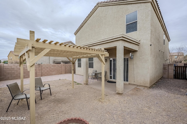 rear view of property featuring a pergola and a patio area