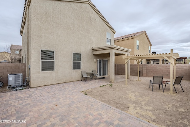 back of house with central AC unit, a pergola, and a patio