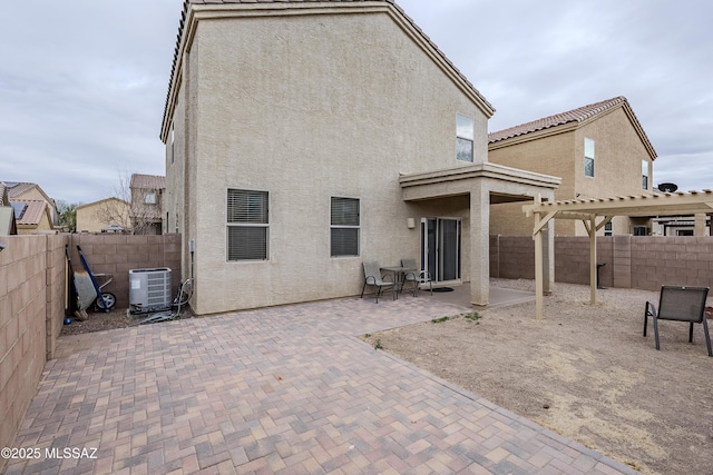 back of house with central AC unit and a patio