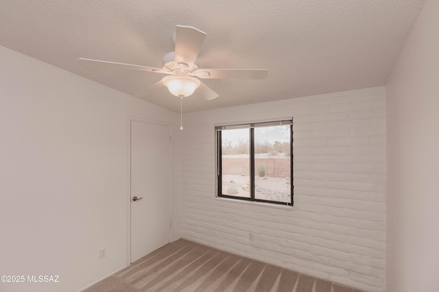 carpeted spare room featuring ceiling fan and a textured ceiling