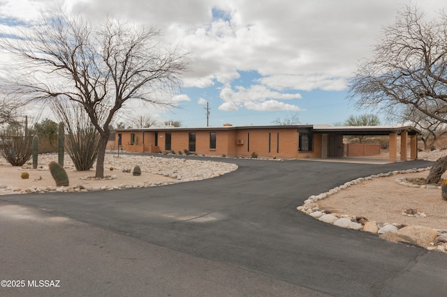 view of front of house featuring aphalt driveway, brick siding, and a carport