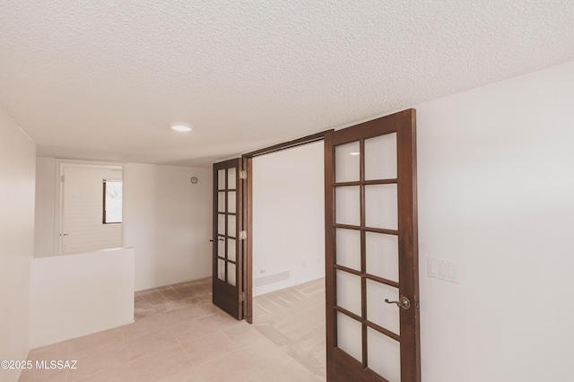 empty room featuring french doors and a textured ceiling