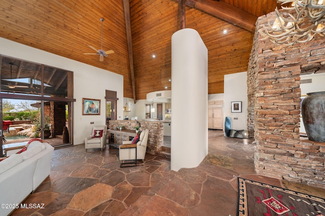 unfurnished living room featuring beam ceiling, ceiling fan, wood ceiling, and a high ceiling