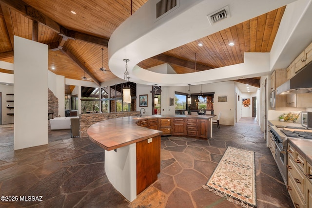 kitchen with kitchen peninsula, hanging light fixtures, wood ceiling, sink, and a kitchen bar