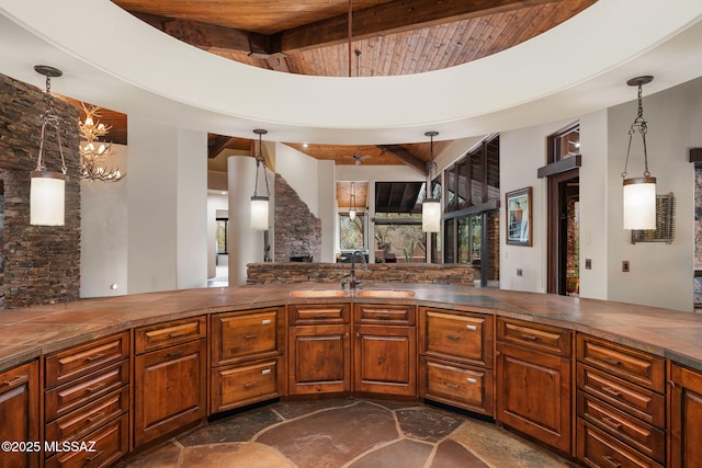 kitchen featuring sink, beam ceiling, wooden ceiling, and pendant lighting