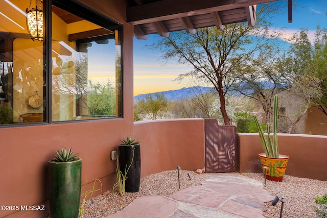 patio terrace at dusk featuring a mountain view