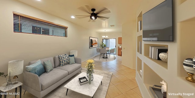 living room featuring ceiling fan with notable chandelier and light tile patterned floors