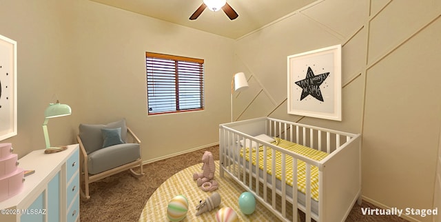 bedroom with ceiling fan, a nursery area, and dark carpet