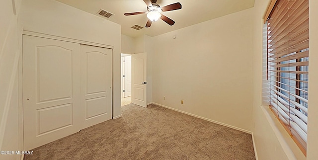 unfurnished bedroom featuring light colored carpet, ceiling fan, and a closet