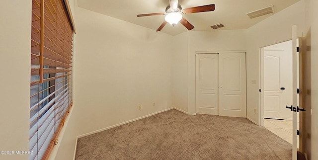 unfurnished bedroom featuring ceiling fan, light colored carpet, and a closet