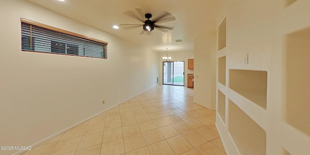 unfurnished room featuring ceiling fan with notable chandelier and light tile patterned floors