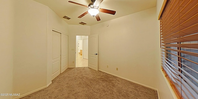 unfurnished bedroom with ceiling fan, a closet, and light carpet