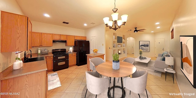 tiled dining space with sink and ceiling fan with notable chandelier