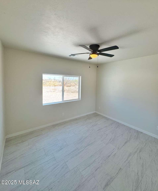 spare room with baseboards and ceiling fan