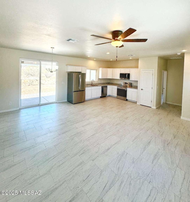 kitchen featuring white cabinets, appliances with stainless steel finishes, a sink, baseboards, and visible vents