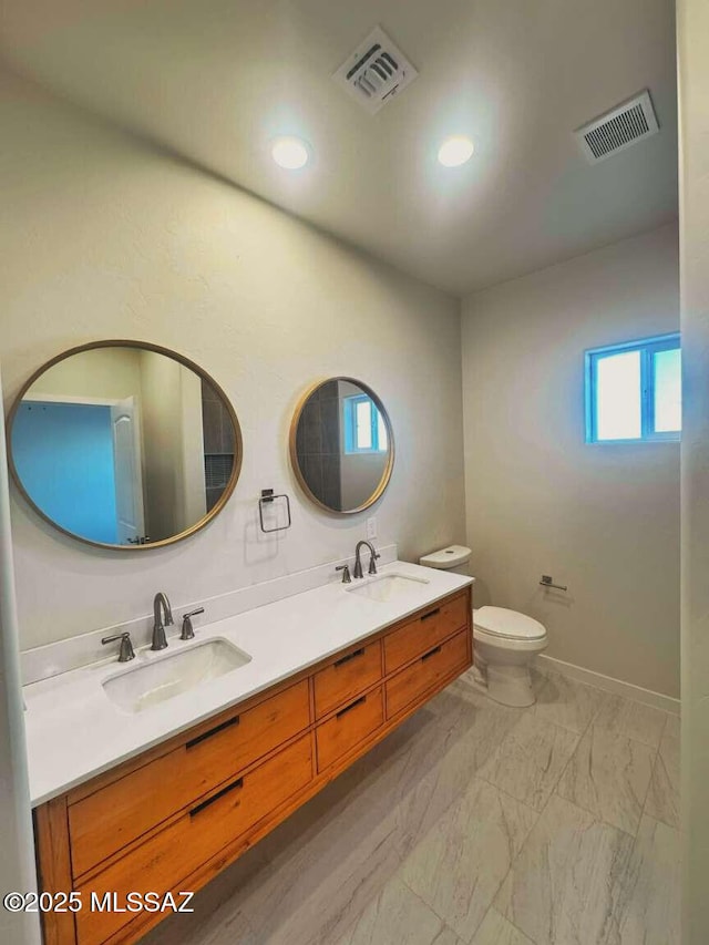 full bathroom featuring a sink, toilet, and visible vents