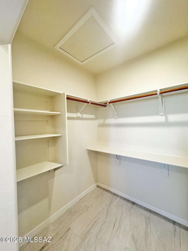 walk in closet with marble finish floor