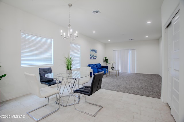 carpeted dining area featuring a chandelier