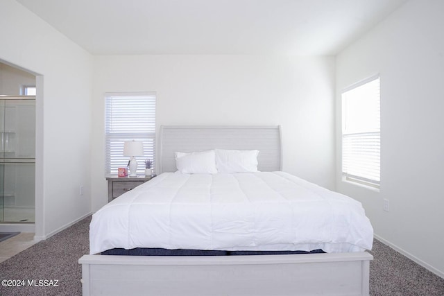 bedroom featuring ensuite bathroom and carpet floors