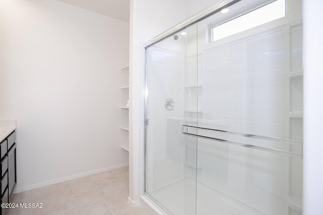 bathroom featuring vanity, tile patterned flooring, and a shower with door