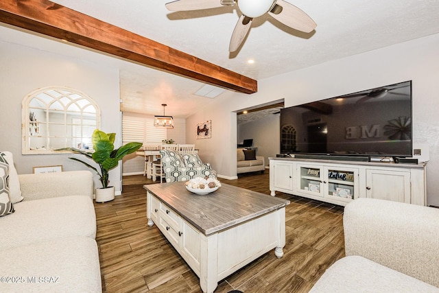 living room with vaulted ceiling with beams, ceiling fan with notable chandelier, and dark hardwood / wood-style flooring