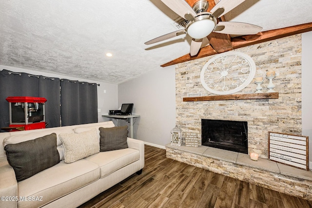 living room featuring hardwood / wood-style floors, a fireplace, lofted ceiling, ceiling fan, and a textured ceiling