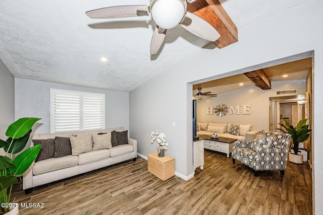 living room with ceiling fan, lofted ceiling with beams, hardwood / wood-style floors, and a textured ceiling