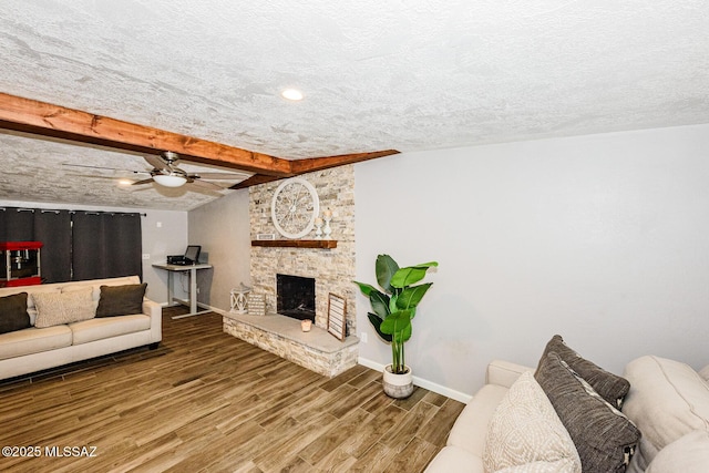 living room featuring a fireplace, wood-type flooring, beamed ceiling, and a textured ceiling