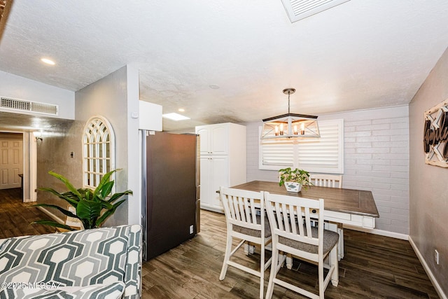 dining area with hardwood / wood-style flooring and a textured ceiling