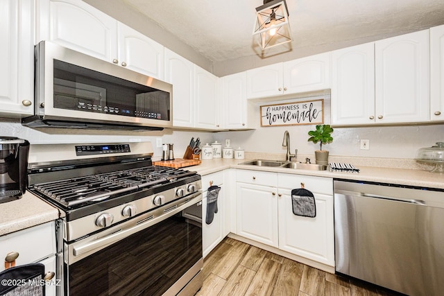 kitchen with white cabinetry, stainless steel appliances, and sink