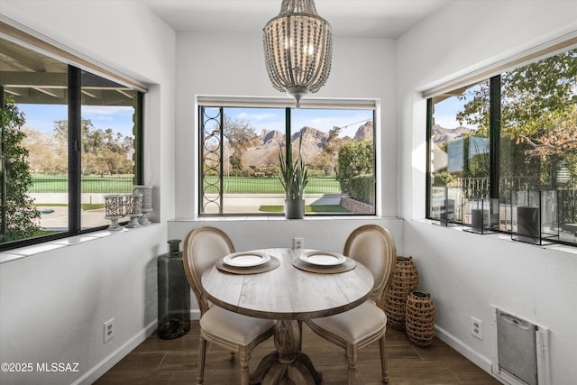 sunroom / solarium with plenty of natural light, a mountain view, and a notable chandelier