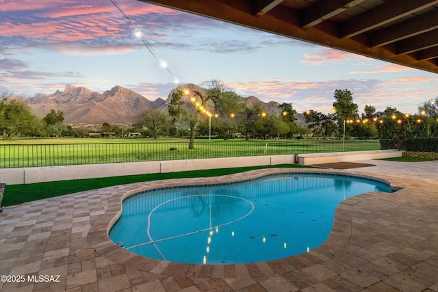 pool at dusk with a mountain view and a patio area