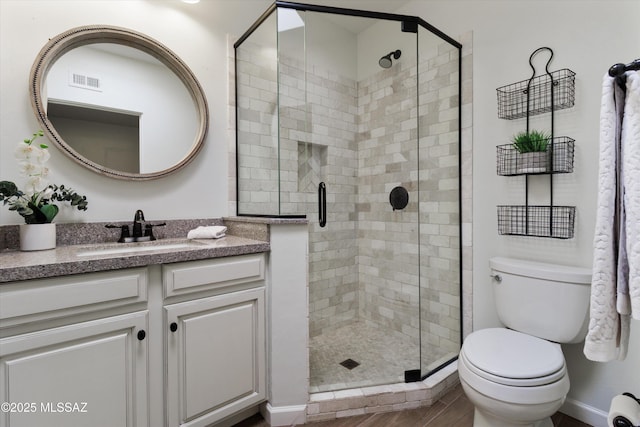 bathroom featuring vanity, toilet, and walk in shower