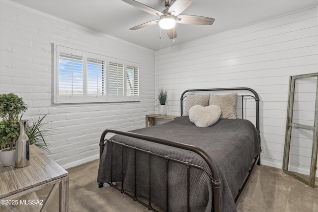 bedroom with ceiling fan, brick wall, and carpet