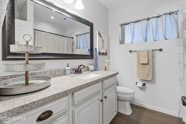 bathroom featuring vanity, hardwood / wood-style floors, a shower with curtain, and toilet