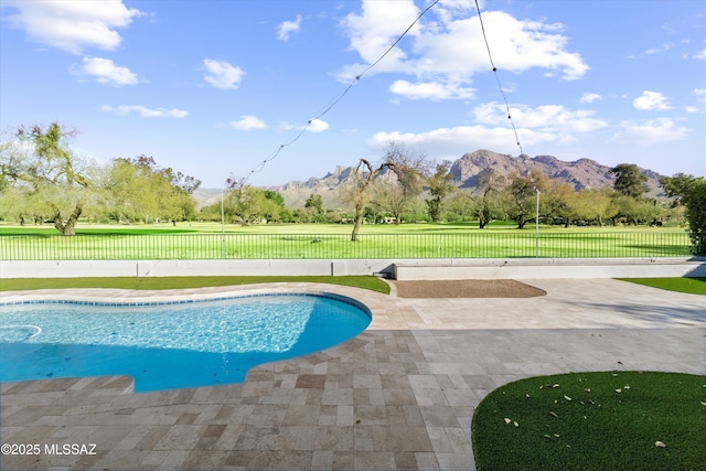 view of swimming pool with a mountain view, a patio area, and a lawn