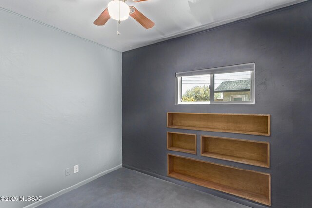 unfurnished room featuring a ceiling fan, baseboards, and concrete flooring
